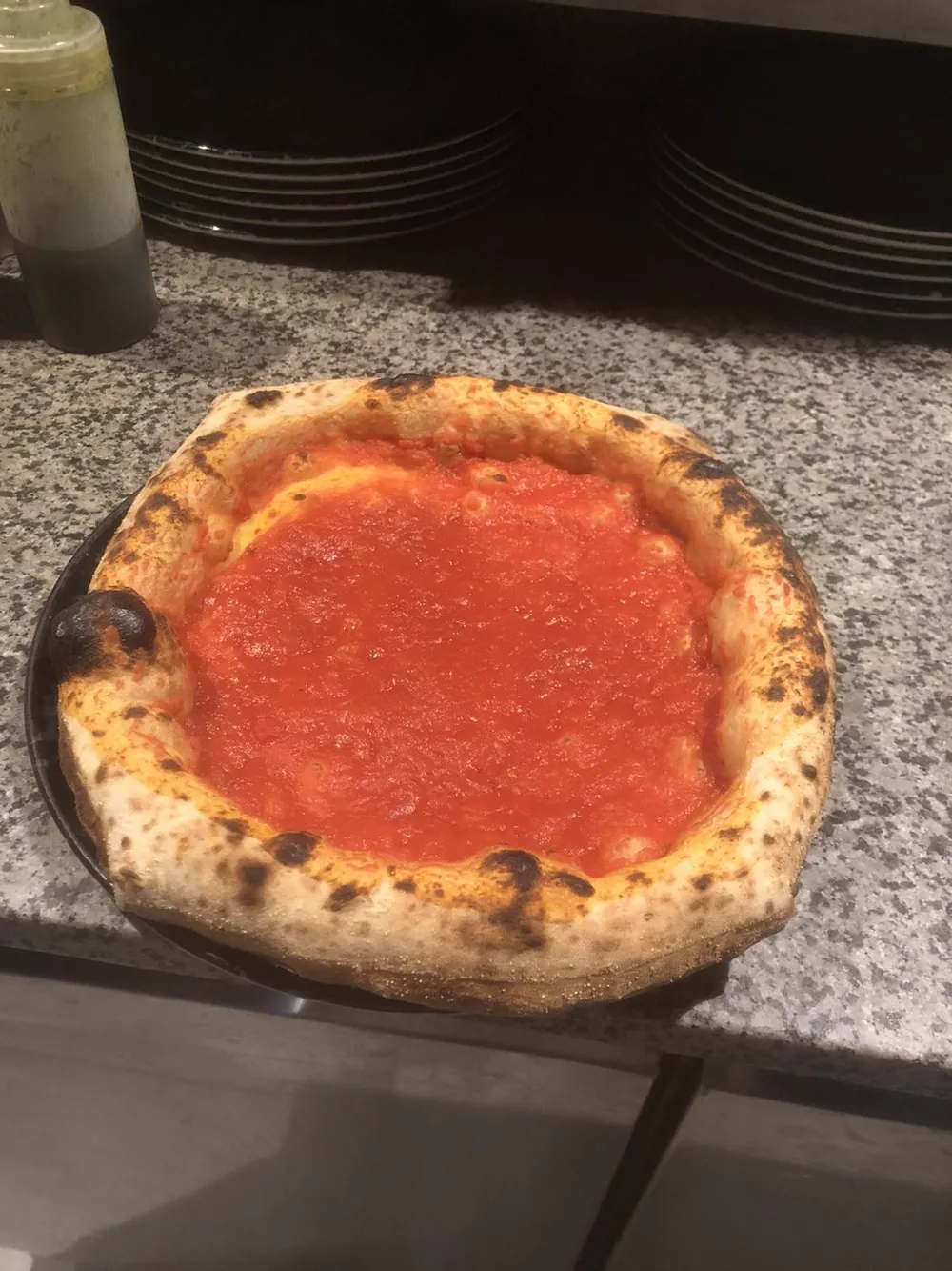 Pizza with a rich San Marzano tomato base and puffed charred crust