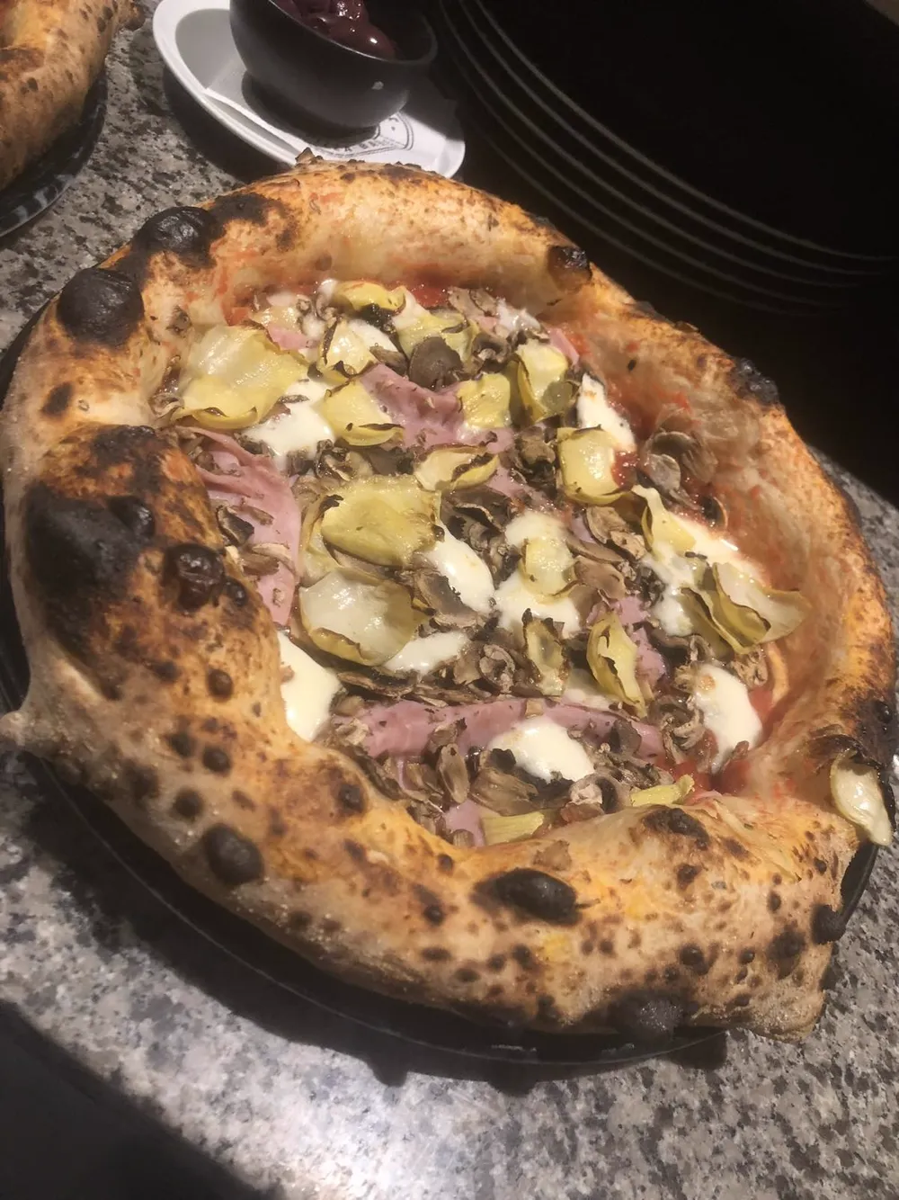 Pizza with cooked ham, artichoke hearts and mushrooms