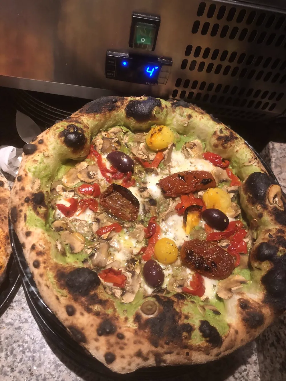 Verdure pizza with pea cream, fior di latte mozzarella, champignons, sun-dried tomatoes, roasted peppers, yellow datterino tomatoes, Kalamata olives, oregano and extra virgin olive oil